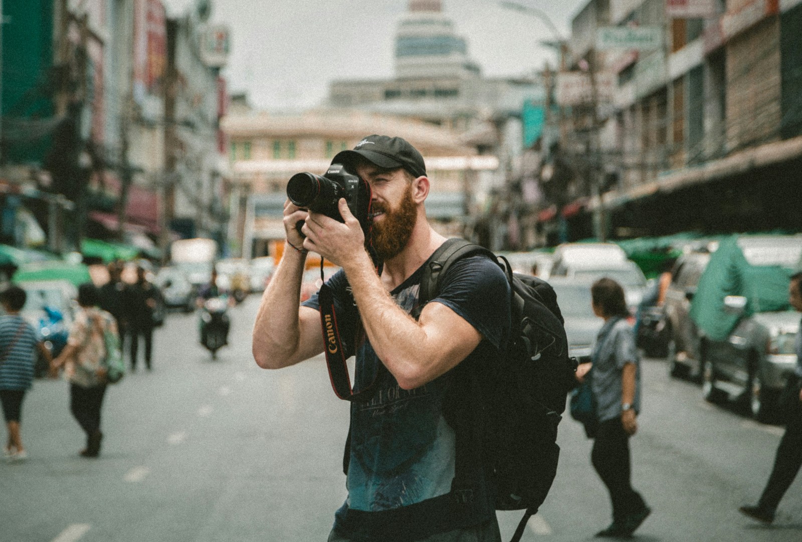 Ulicni fotograf snima DSLR fotoaparatom na prometnoj gradskoj ulici