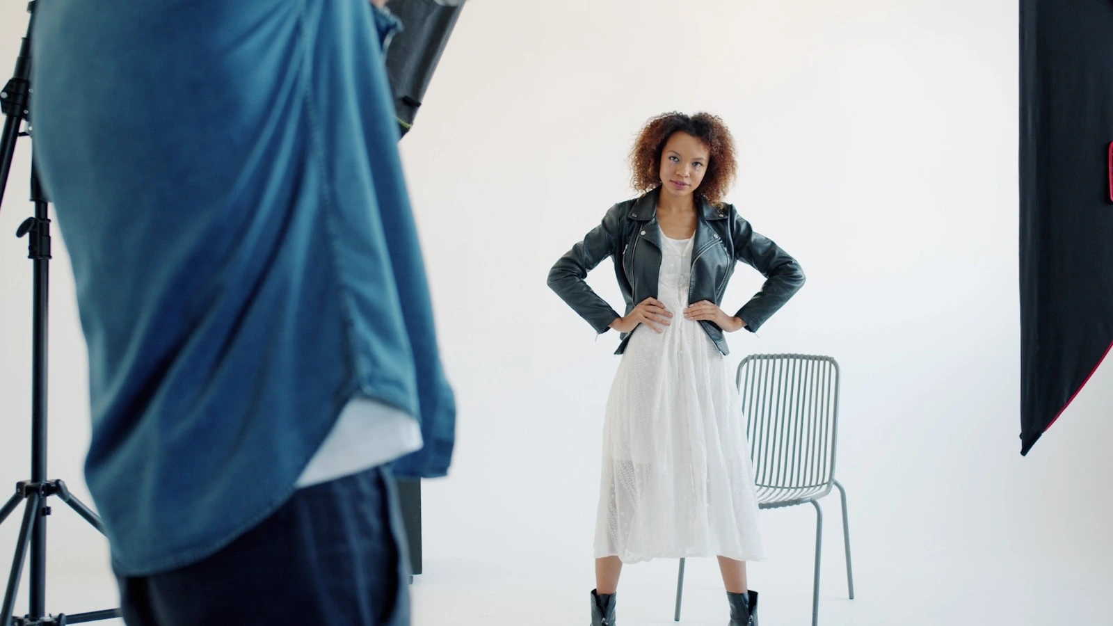 Model pozira ispred bijele pozadine dok je fotograf snima